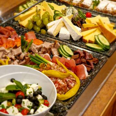 Frühstücksbuffet mit Fleisch, Käse und Apfelstrudel