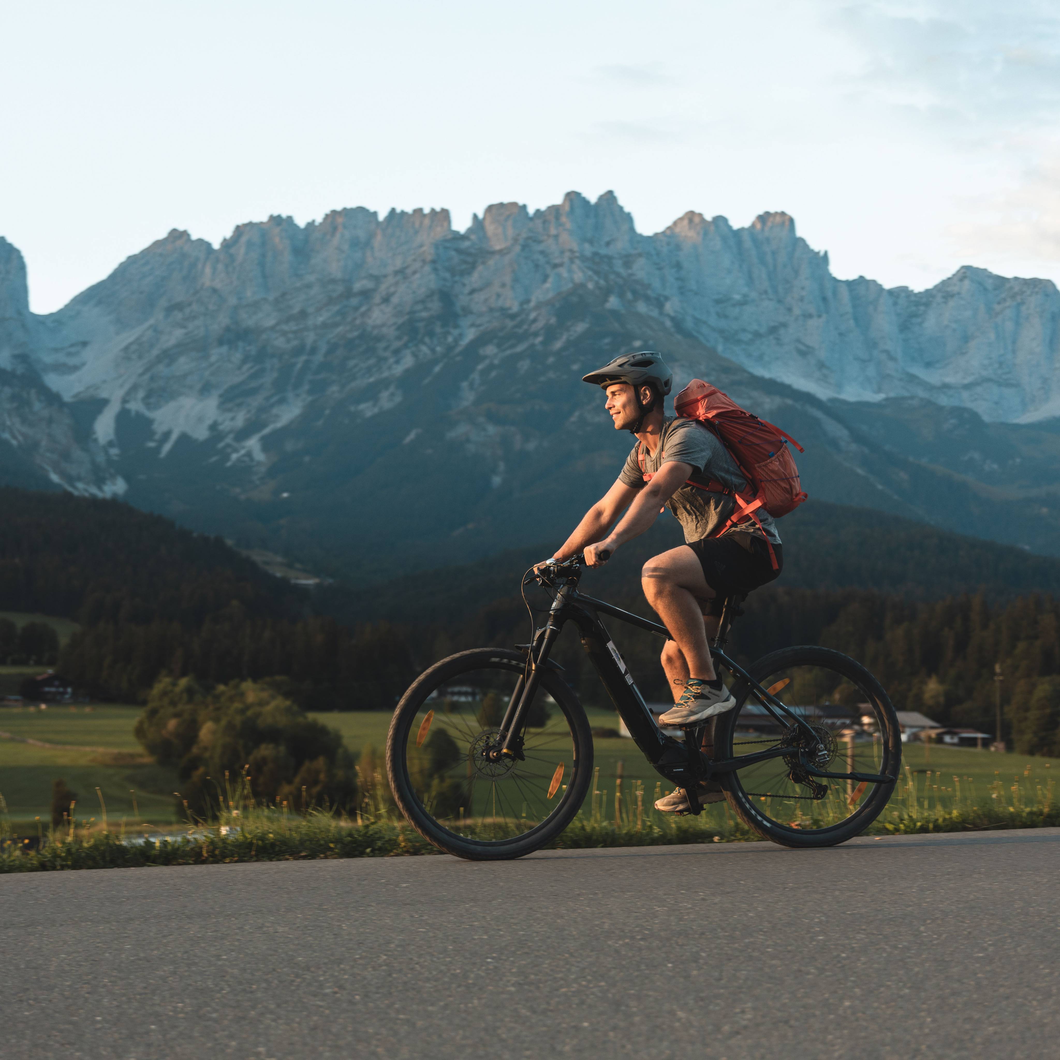 Mountainbiker fährt auf Straße am Wilden Kaiser