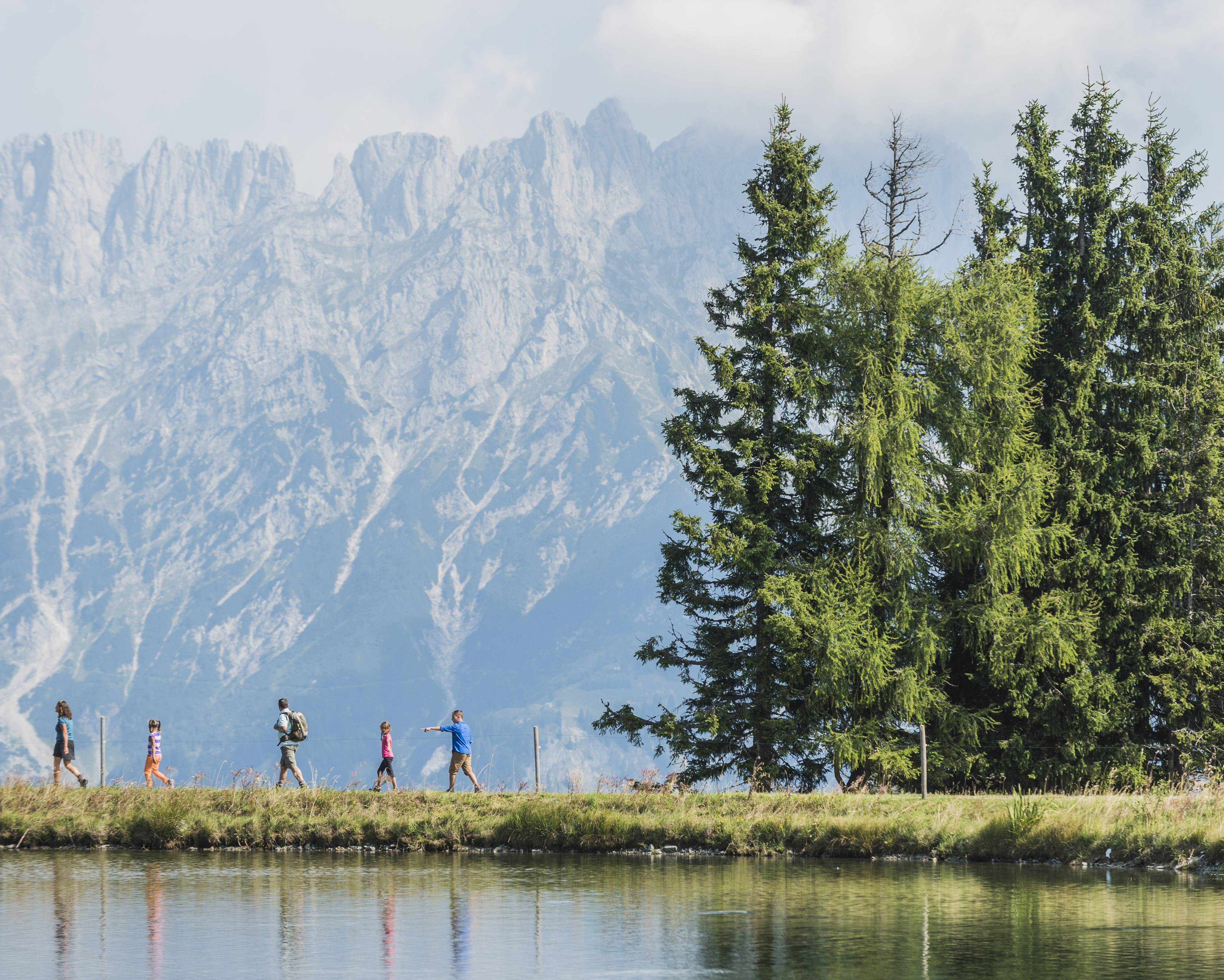 Familie wandert am See am Fuße des Wilden Kaisers