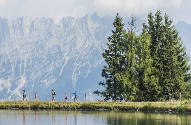 Familie wandert am See am Fuße des Wilden Kaisers