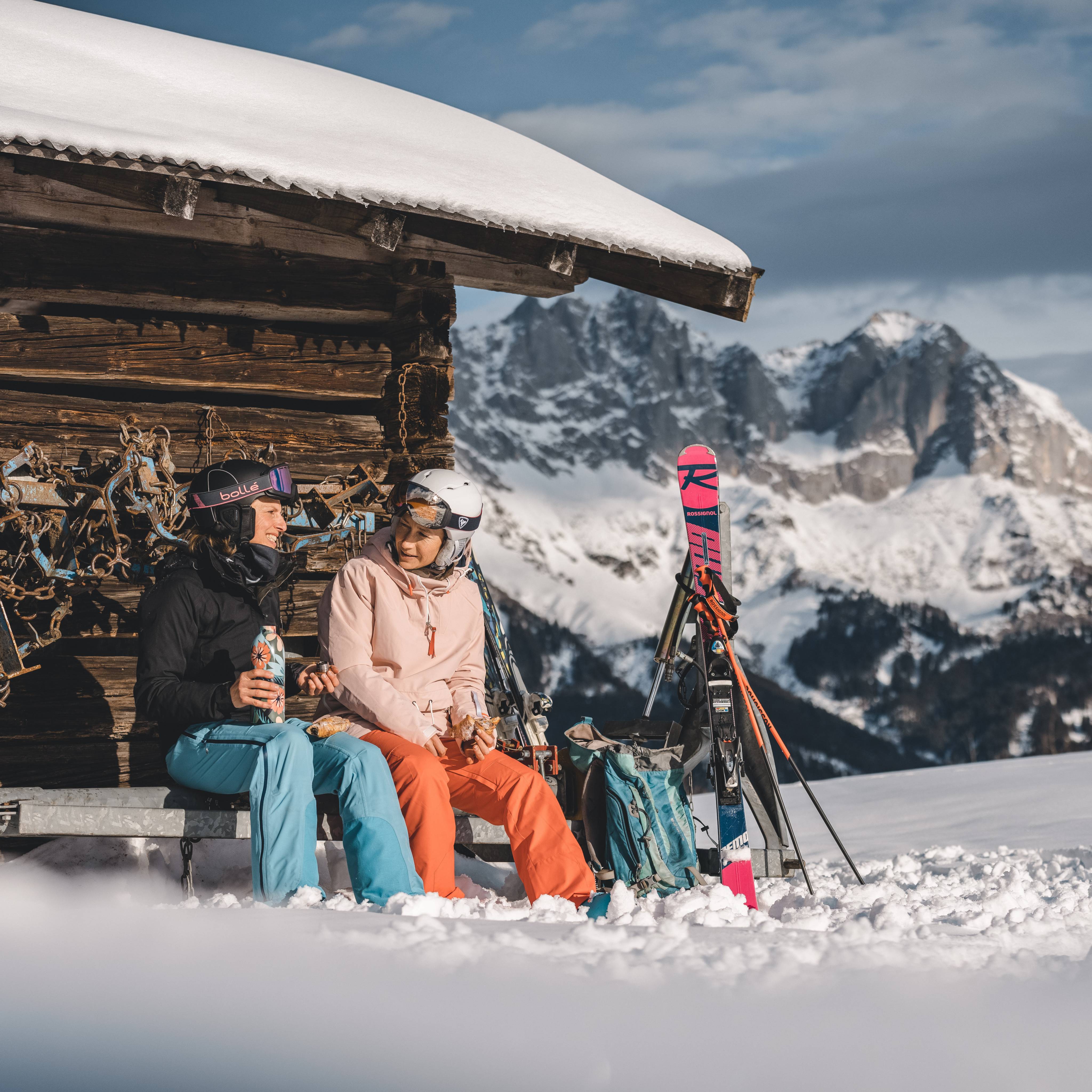 Skifahrer machen eine Pause an Holzhütte